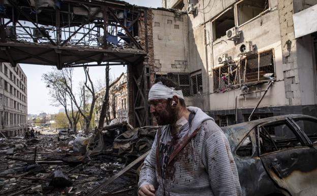 An injured man walks through the ruins of Kharkiv./EP