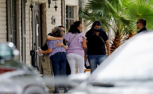 People hug at the entrance to the funeral home where Nevaeh Alyssa Bravo, one of the victims of the mass shooting at Robb Elementary School, lies./REUTERS