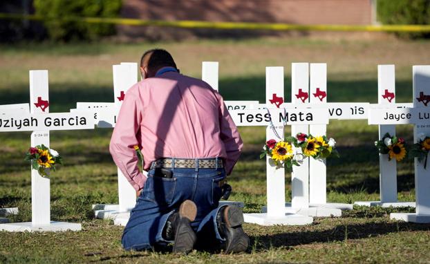 Duel.  Pastor Daniel Myers prays in front of the funeral crosses of the victims of the massacre at Robb Elementary School./REUTERS