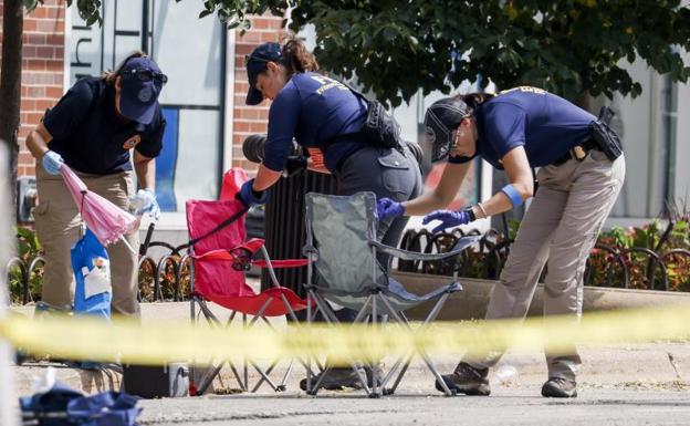 Agents recover evidence at the scene of the shooting in Highland Park.  /Eph